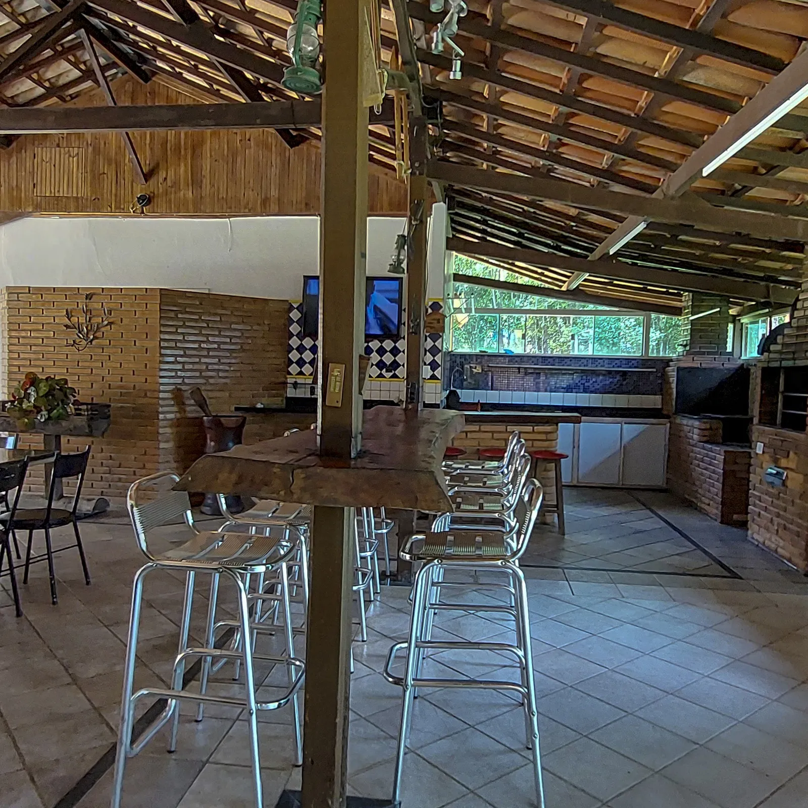 Área gourmet com forno a lenha, bar e mesas
