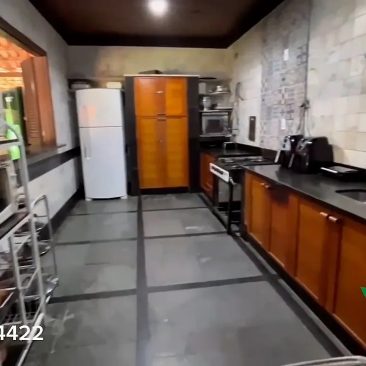 Cozinha com armários de madeira e paredes em mármore