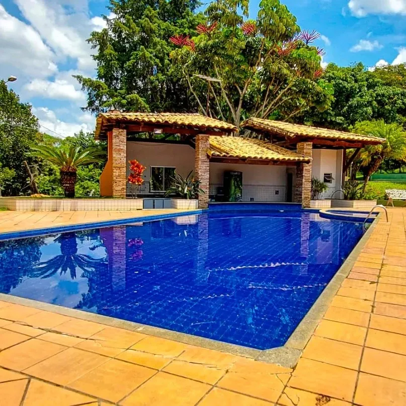 Piscina de 13 por 6 metros em dia de sol, com deck ao redor