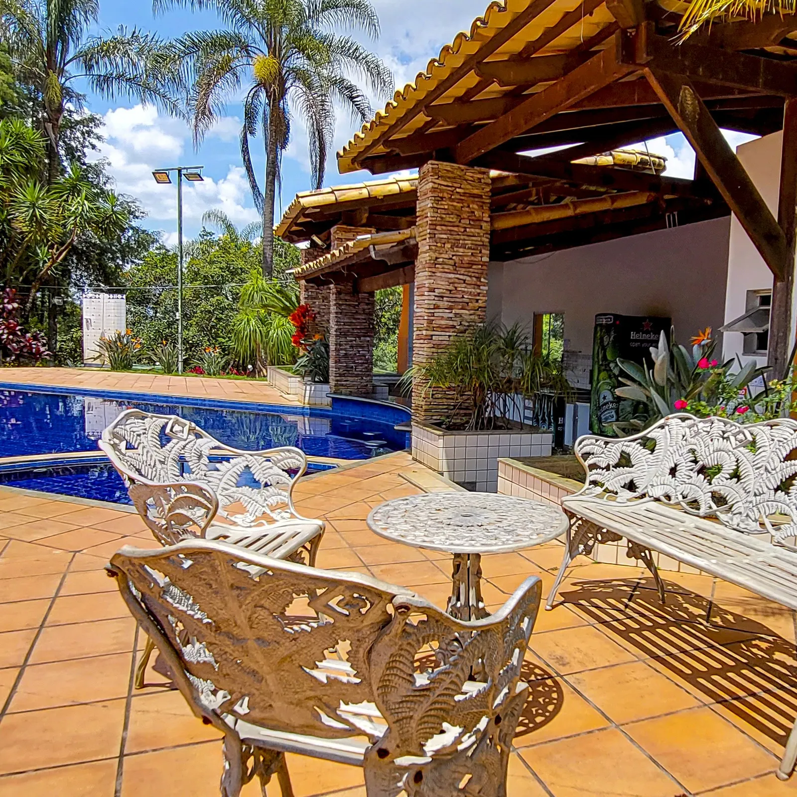 Mesa e cadeiras de jardim à beira da piscina