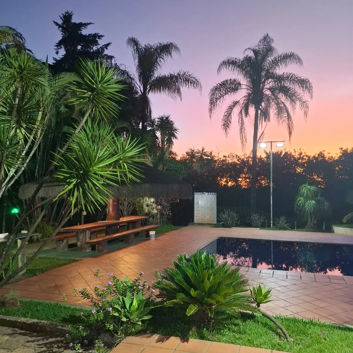 Piscina e quiosque ao pôr do sol