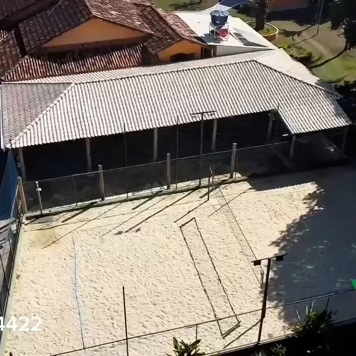 Vista aérea da quadra de areia coberta, com rede de vôlei