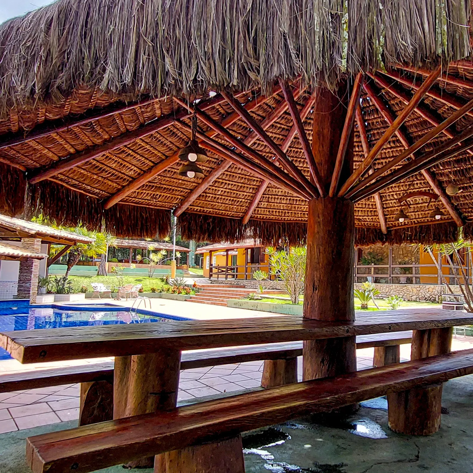 De dentro do quiosque de piaçava, olhando para a piscina