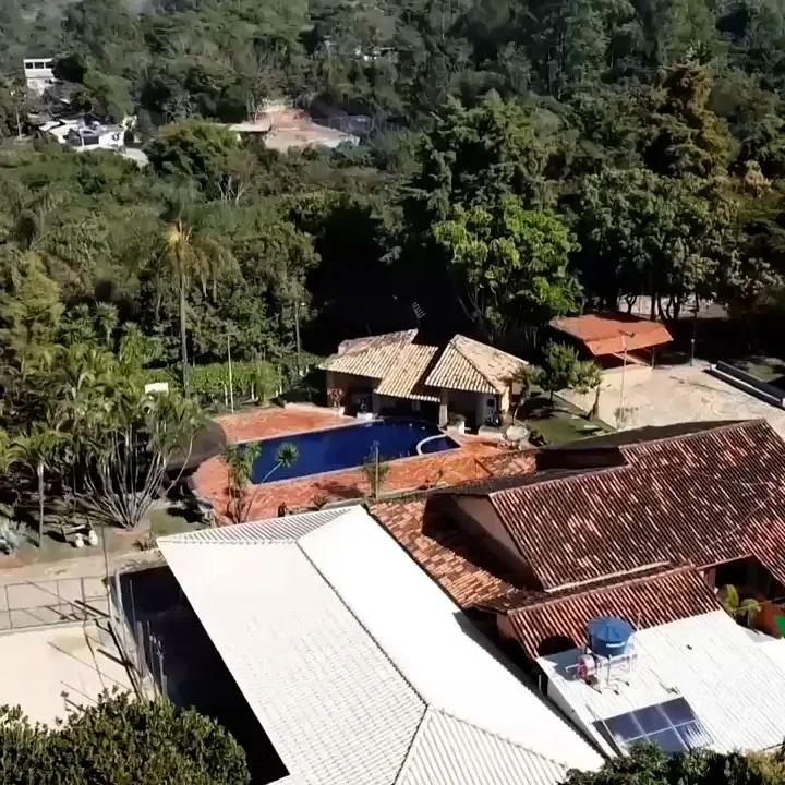 Vista aérea do sítio, com o salão de festas coberto, a piscina e a área verde